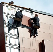 Мастера выполняют облицовку верхних этажей жилого дома  